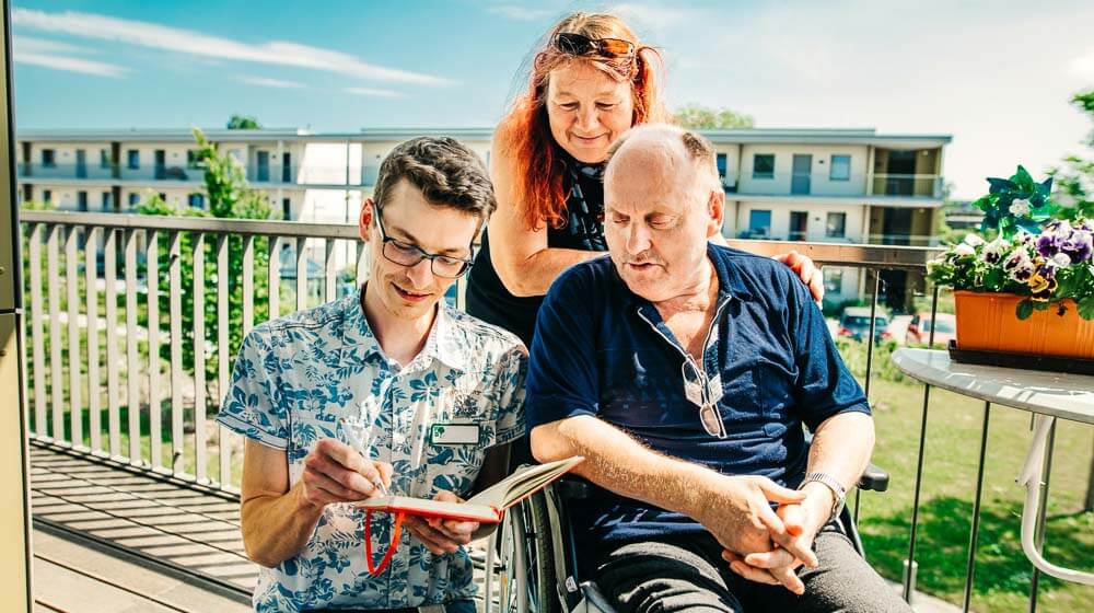 Zwei Pflegefachkräfte sind bei einem Gast im Rollstuhl im Senioren- und Wohnzentrum am Botanischen Garten